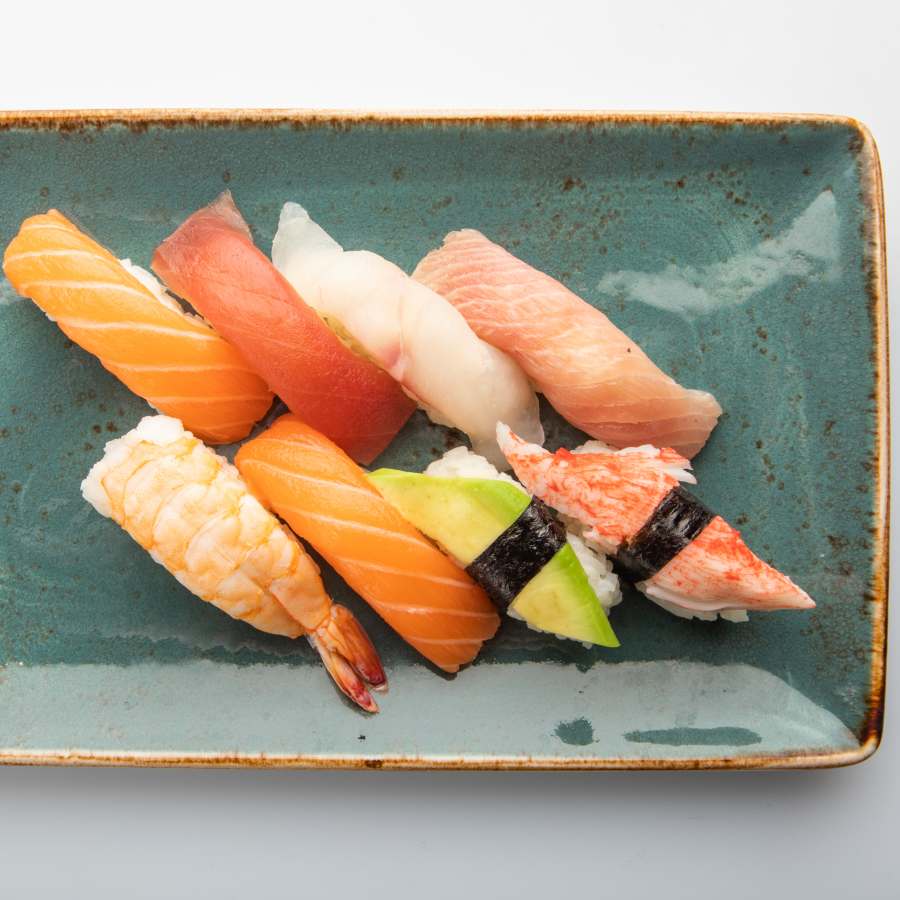 8 nigiri misti su piatti di ceramica verde acqua